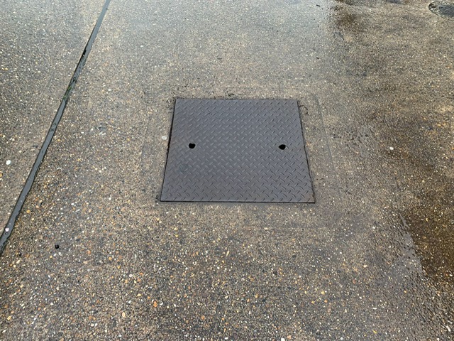 Metal manhole cover on forecourt